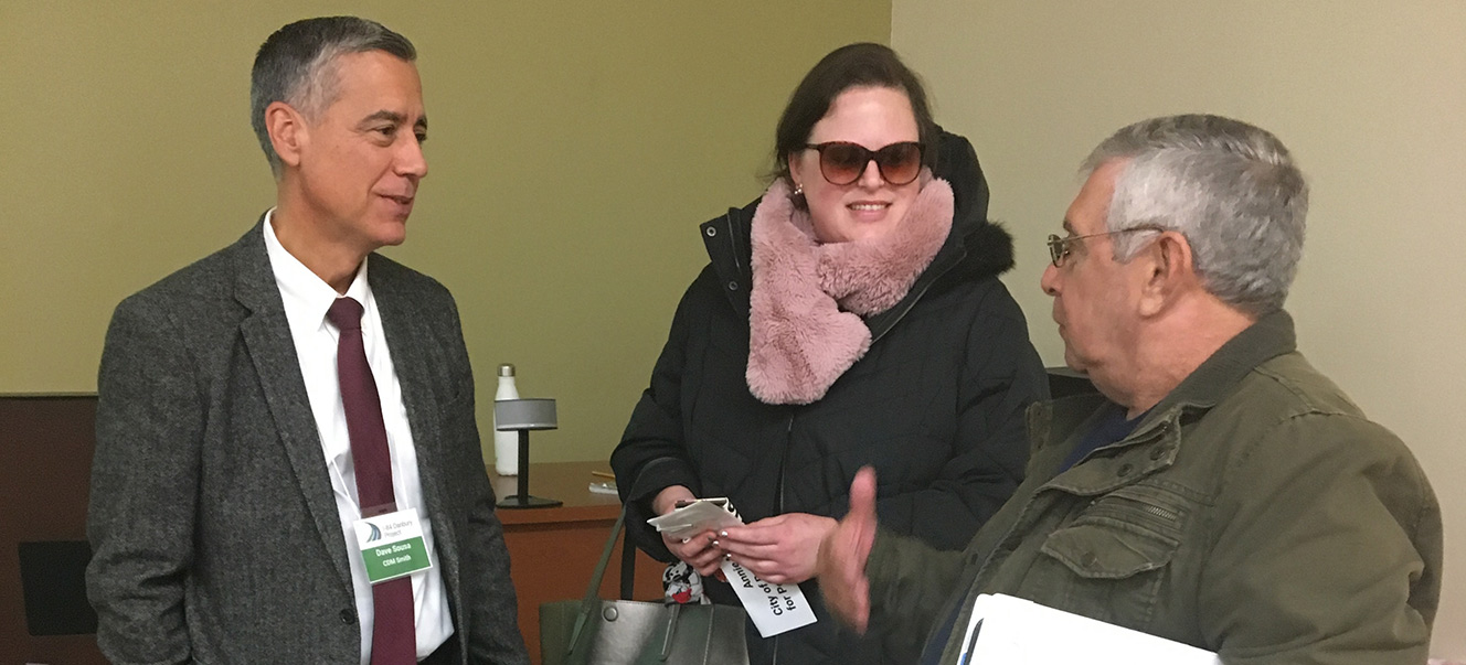 Photo of two men and one woman talking